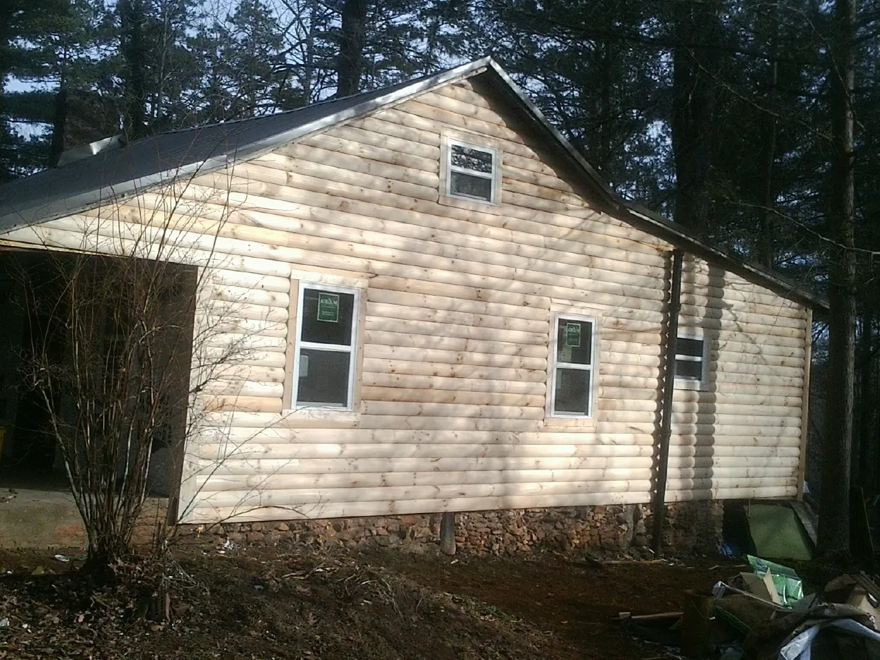 New log siding and dark metal roofing on a gable end in Dana